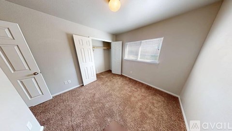 A room with a carpeted floor and a door in the middle.