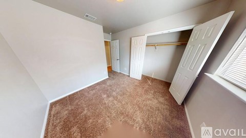 A room with a brown carpet and white walls.