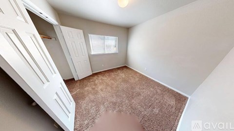 A room with a brown carpet and white walls.