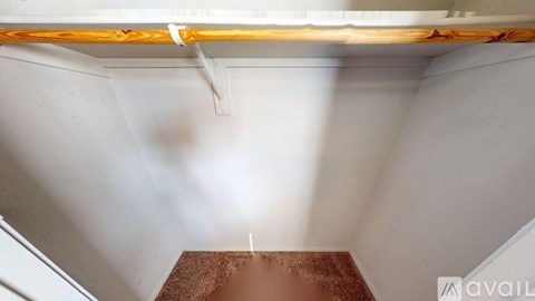 A room with a brown floor and white walls.