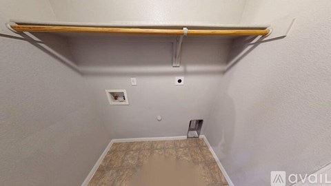 A small room with a brown tile floor and a white wall.