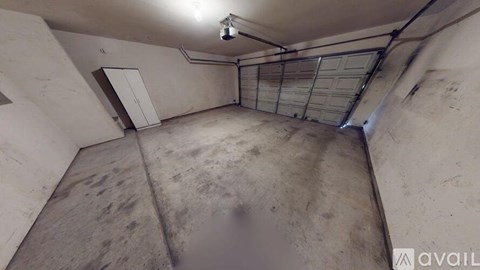 A large, empty garage with a concrete floor and walls.