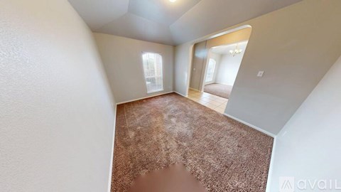A room with a brown carpet and white walls.