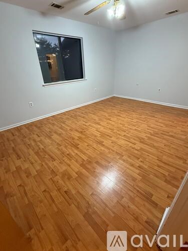 A room with wooden flooring and a window.