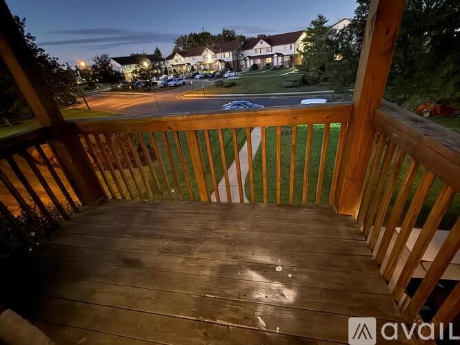A wooden deck overlooks a parking lot at dusk.