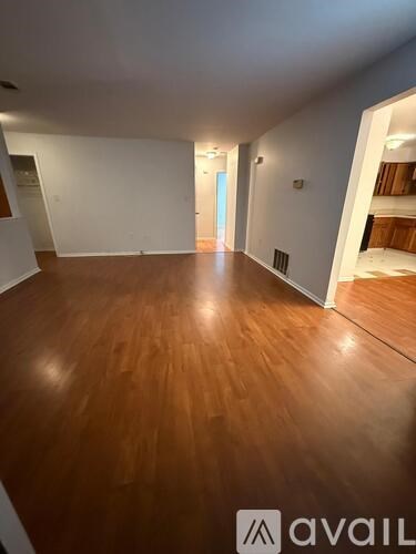 A room with wooden flooring and white walls.