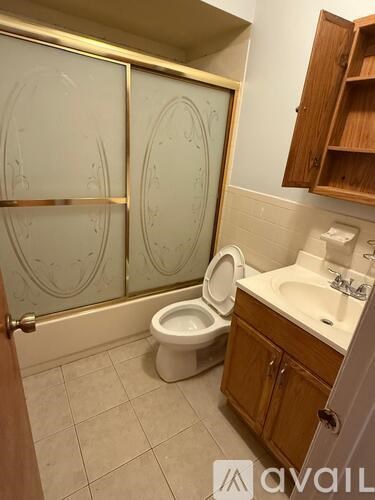 A bathroom with a toilet, sink, and shower.