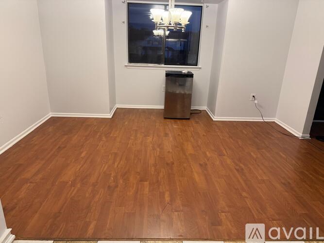 A room with wooden flooring and a window.