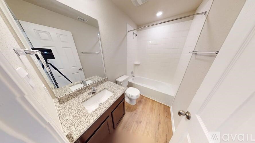 A bathroom with a sink, mirror, and toilet.