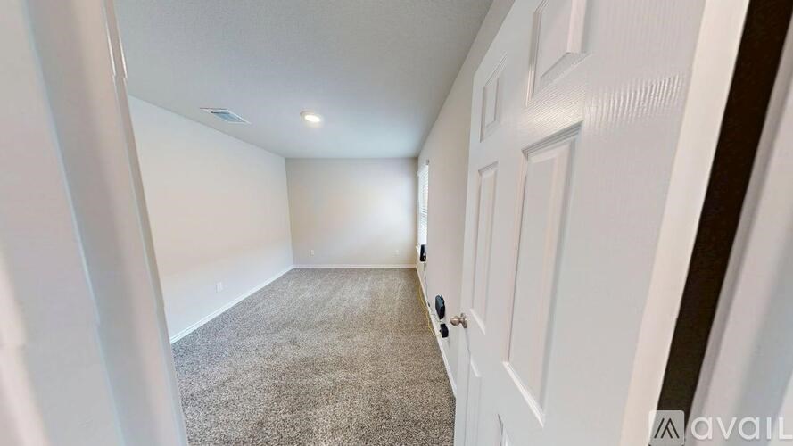 A room with a carpeted floor and white walls.