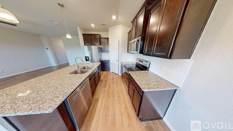 A kitchen with granite countertops and stainless steel appliances is available for rent.