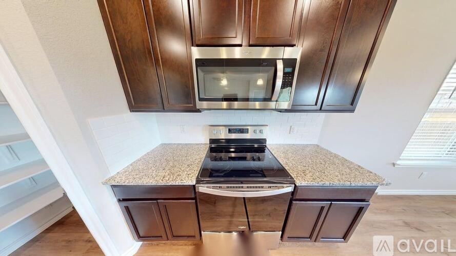 A kitchen with a granite countertop and a stainless steel oven.