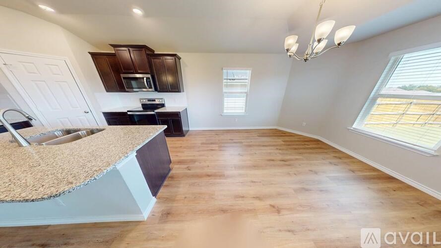 A kitchen with wooden floors and a countertop with a sink.