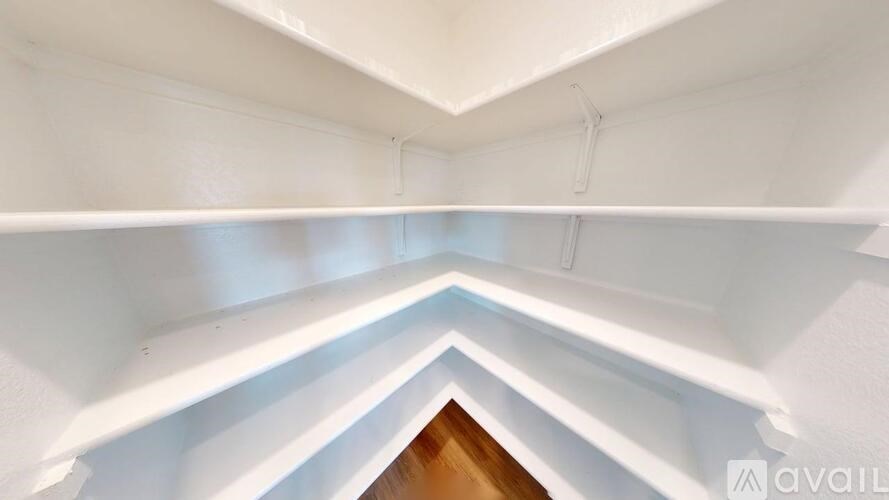 A white shelving unit with a wooden floor at the bottom.