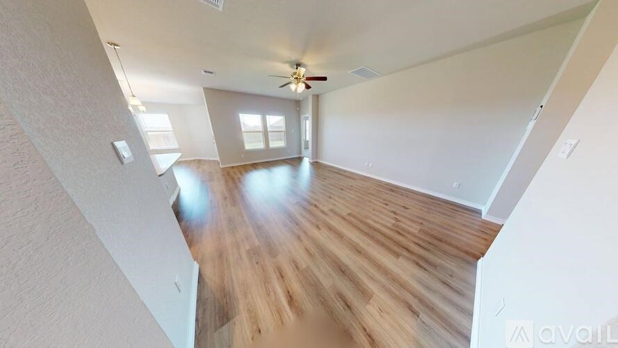 A room with wooden floors and a ceiling fan.