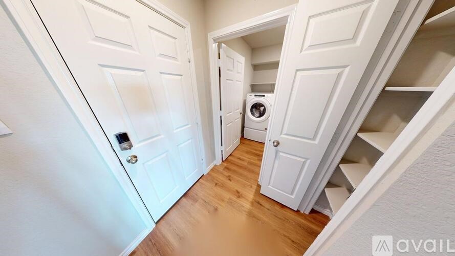 A hallway with white doors and a washing machine in the corner.