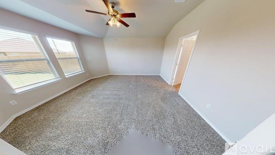 A room with a ceiling fan and carpeted floor.