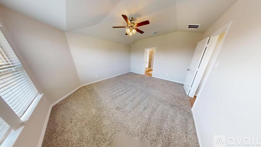 A room with a carpeted floor and a ceiling fan.