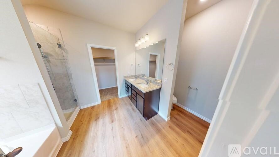 A room with wooden floors and a vanity with a mirror.