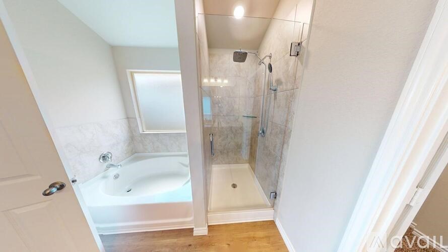 A white bathroom with a tub and shower.