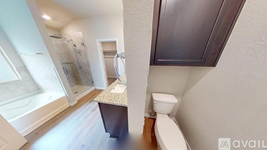 A bathroom with a toilet, sink, and shower.