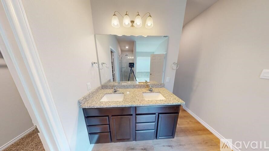 A bathroom with a granite countertop and a vanity with a mirror above it.