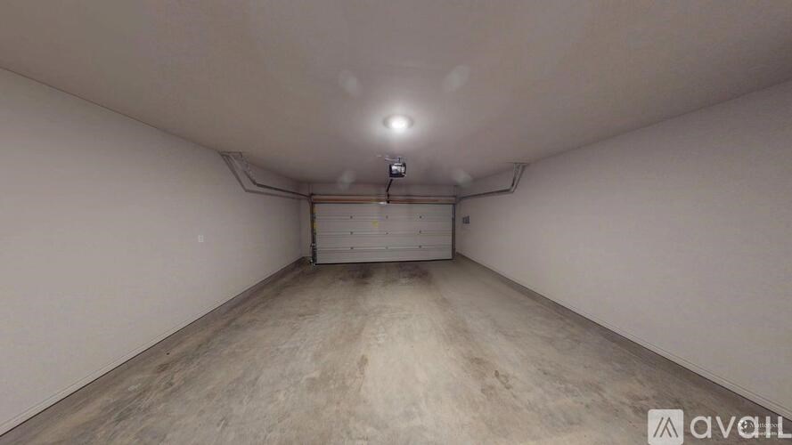 A spacious room with a white ceiling and a wooden floor.