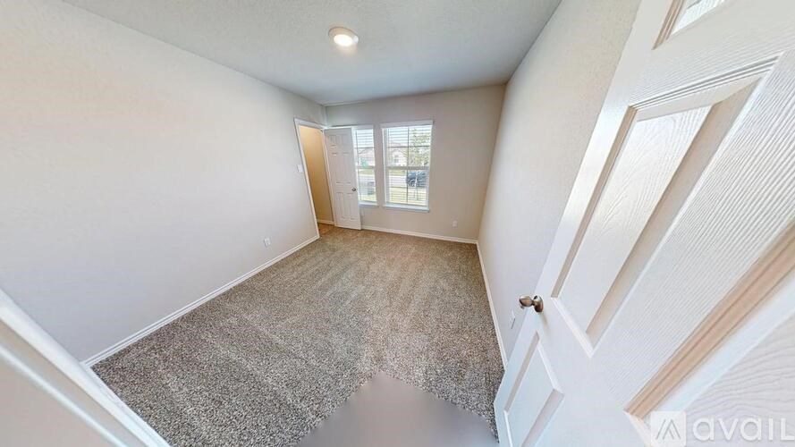 A room with a carpeted floor and a door leading to a balcony.