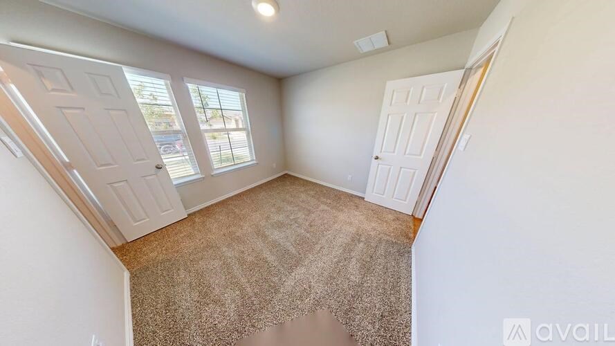 A room with a carpeted floor and a window.