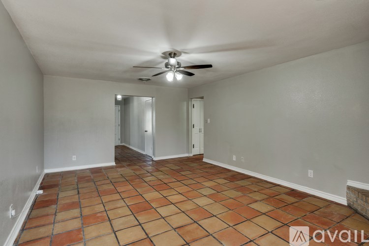 A room with a ceiling fan and tile flooring.