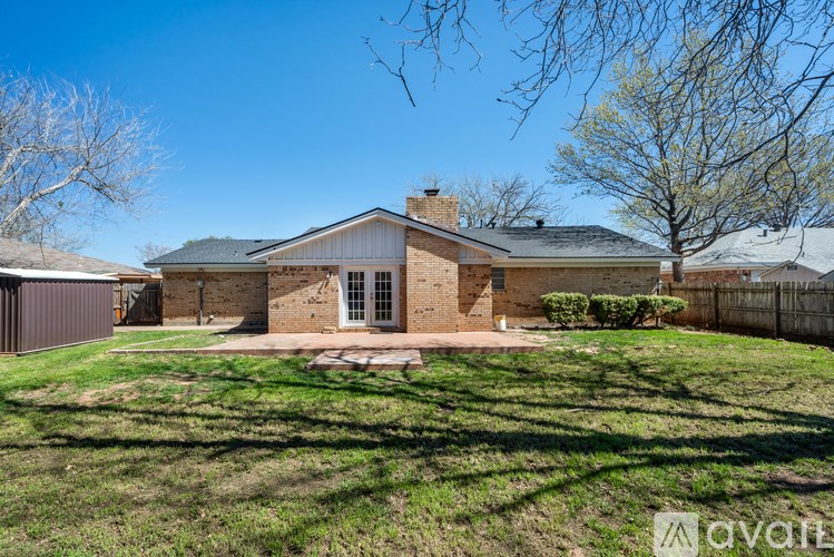 A house with a brick chimney and a large lawn in front.