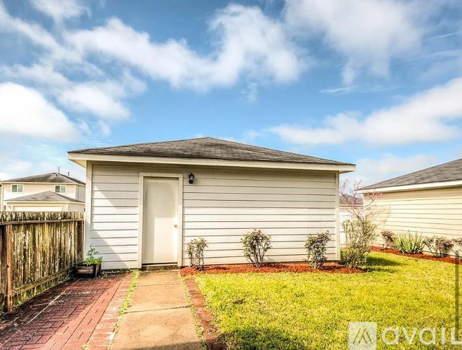A small house with a white door and a brown fence.
