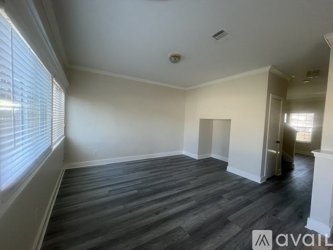 A room with wooden flooring and white walls is available for rent.