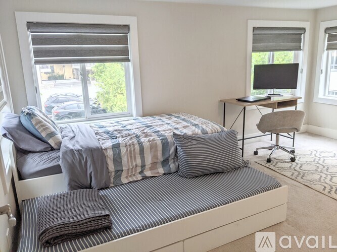 A bedroom with a bed, desk, and chair.