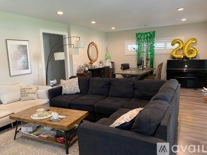 A living room with a black couch and a coffee table.