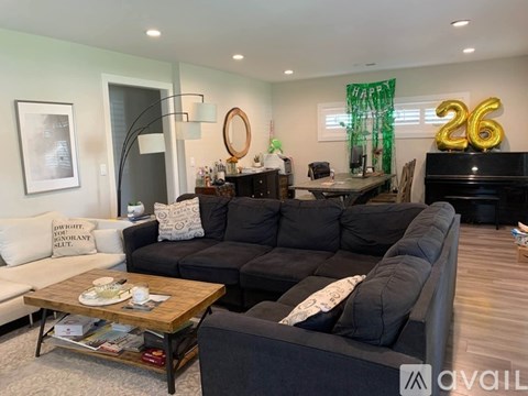 A living room with a black couch and a coffee table.