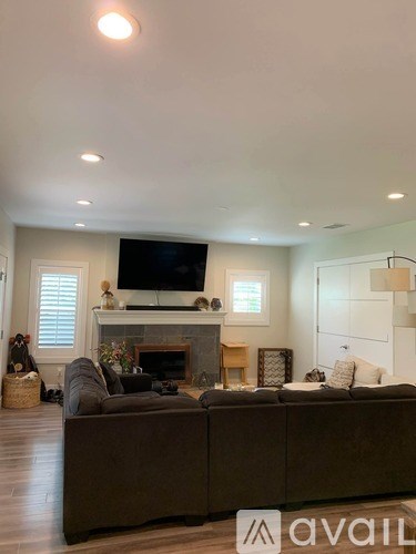 A living room with a brown couch and a fireplace.