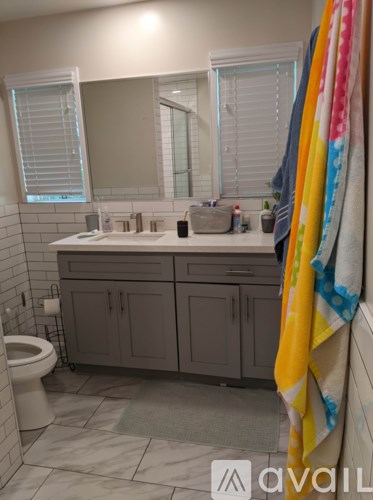 A bathroom with a white toilet and a white sink with a mirror above it.