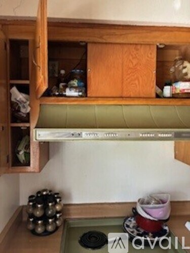 A kitchen with a green mat on the floor and a wooden cabinet above it.