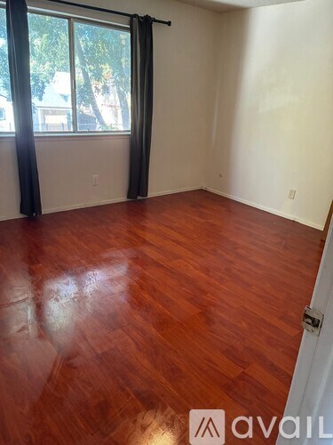 A room with wooden flooring and a sliding glass door.