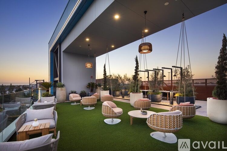 A patio with white furniture and hanging lights.