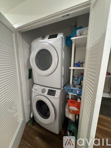 A small laundry room with a washer and dryer stacked on top of each other.
