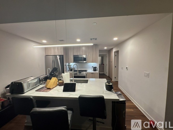 A modern kitchen with a breakfast bar and chairs.