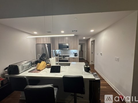 A modern kitchen with a breakfast bar and chairs.