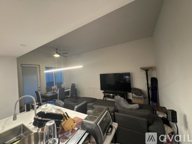 A kitchen area with a sink, a counter, and a couch.