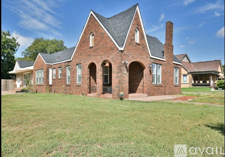 A brick house with a pitched roof and a chimney is for sale.