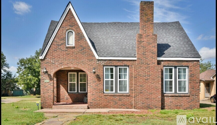 A red brick house with a pitched roof and a chimney.