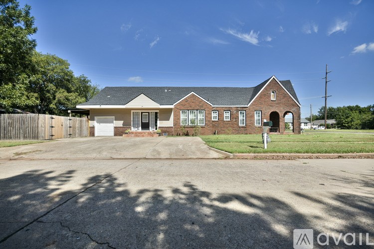 A house with a brick facade and a white garage door is for sale.