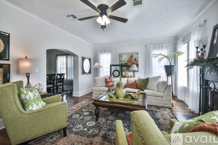 A living room with a green chair and a rug.