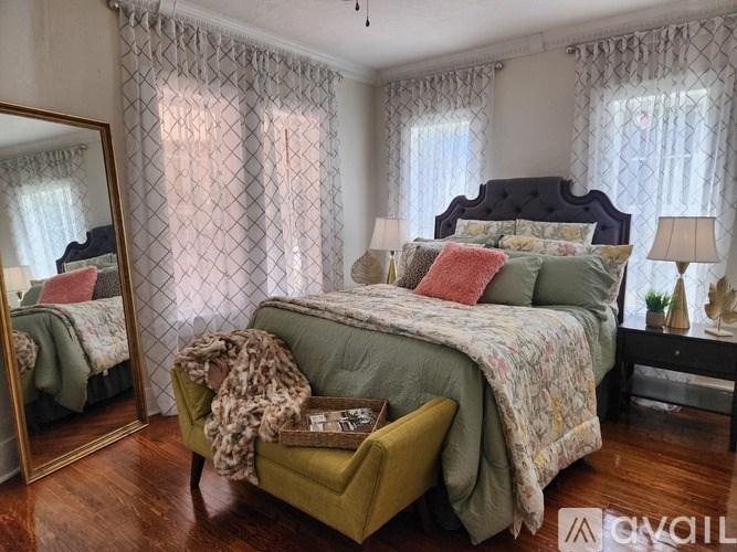 A bedroom with a large bed and a green chair.